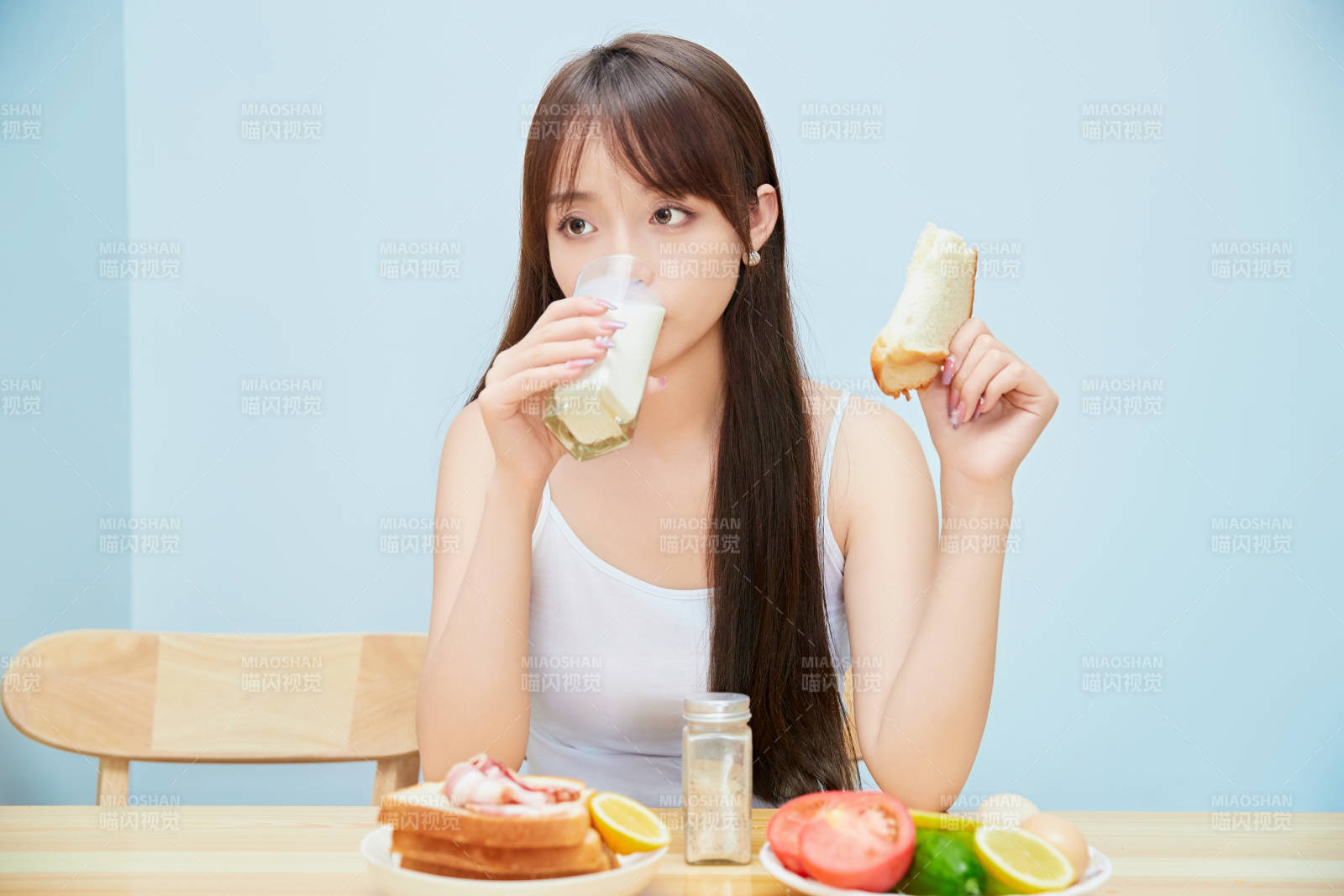 美丽的少女在餐桌前吃早餐图片