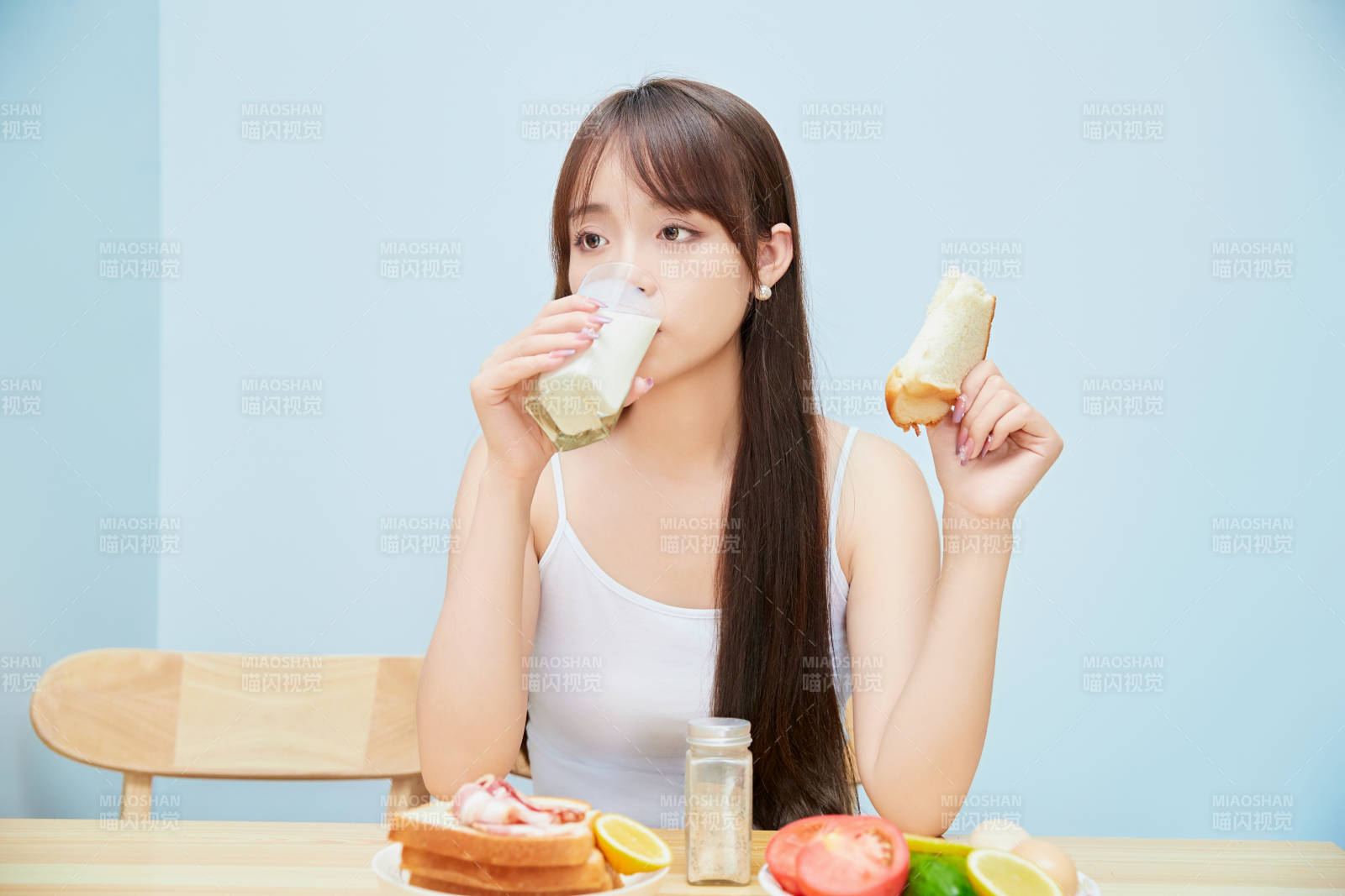 美丽的少女在餐桌前吃早餐图片