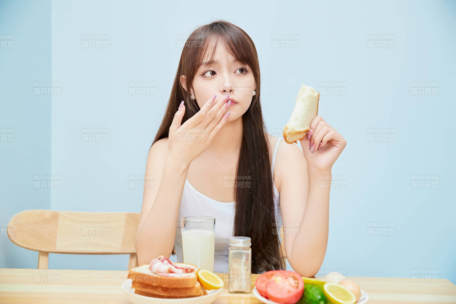 美丽的少女在餐桌前吃早餐图片