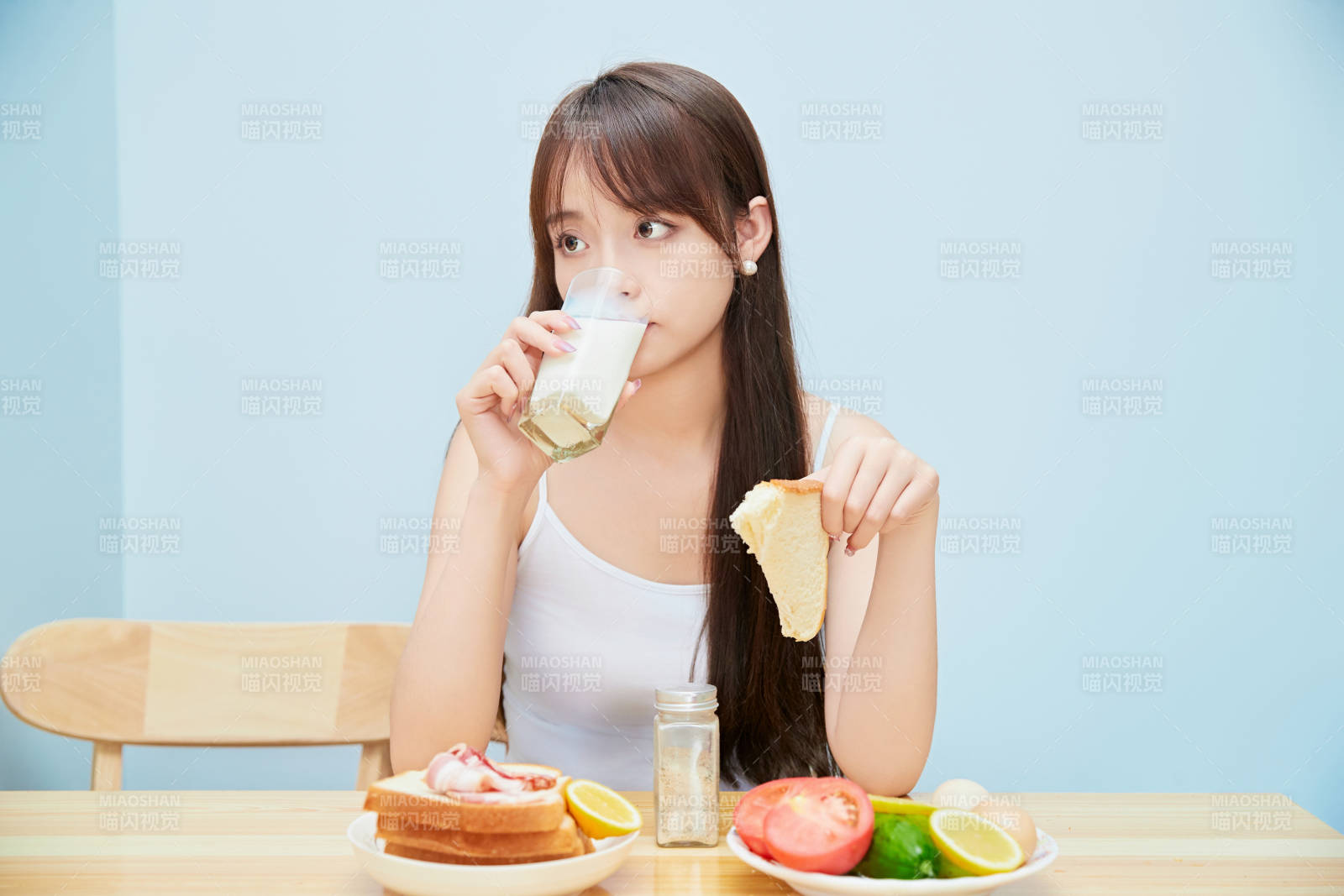 美丽的少女在餐桌前吃早餐图片