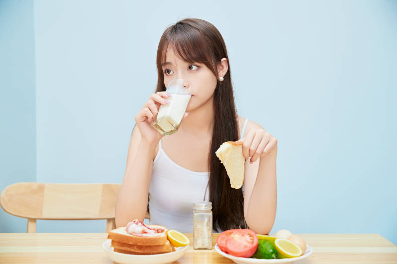 美丽的少女在餐桌前吃早餐图片