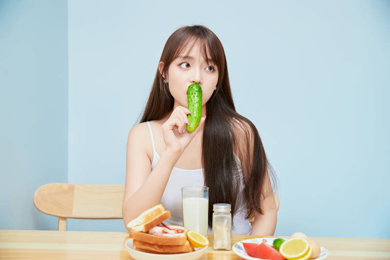 美丽的少女在餐桌前吃早餐图片