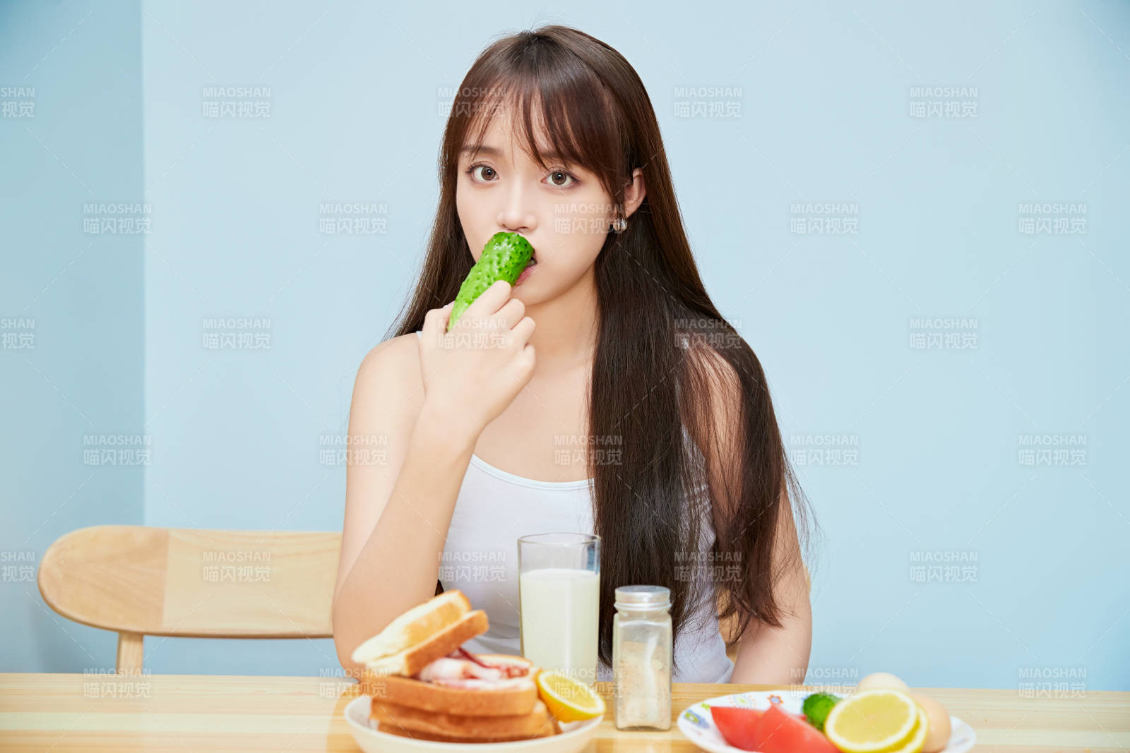美丽的少女在餐桌前吃早餐图片