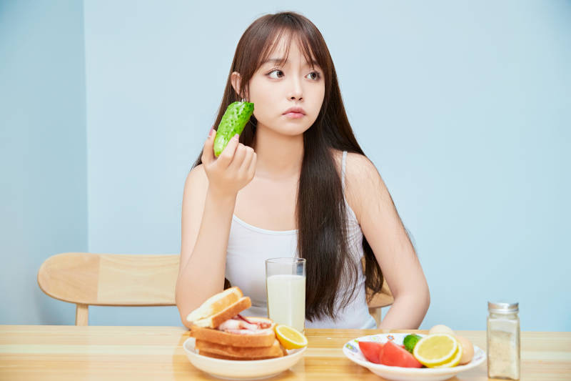 美丽的少女在餐桌前吃早餐图片