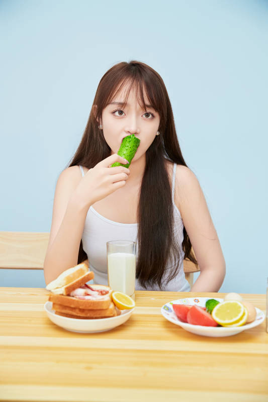 美丽的少女在餐桌前吃早餐图片