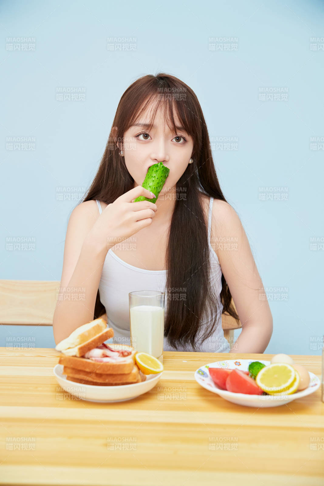 美丽的少女在餐桌前吃早餐图片