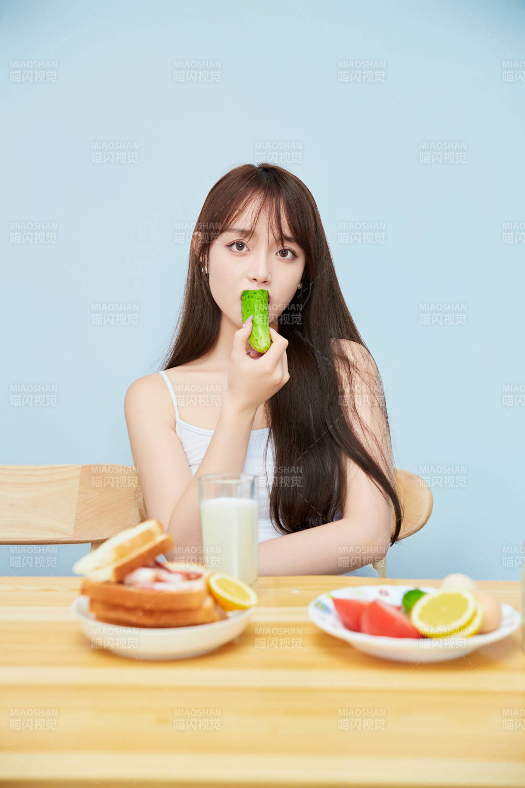 美丽的少女在餐桌前吃早餐图片