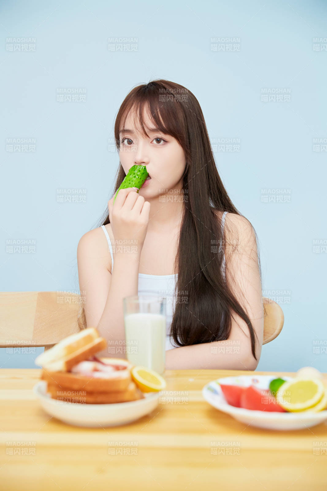 美丽的少女在餐桌前吃早餐图片