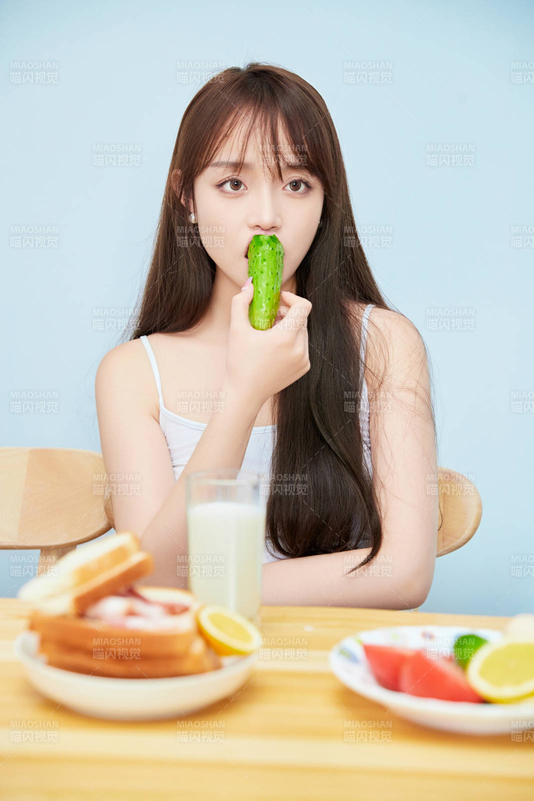 美丽的少女在餐桌前吃早餐图片