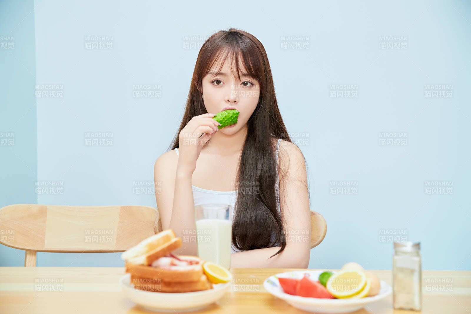 美丽的少女在餐桌前吃早餐图片