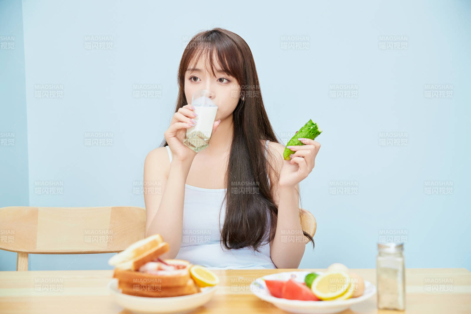 美丽的少女在餐桌前吃早餐图片