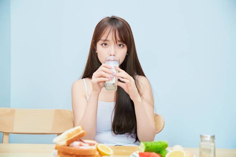 美丽的少女在餐桌前吃早餐图片