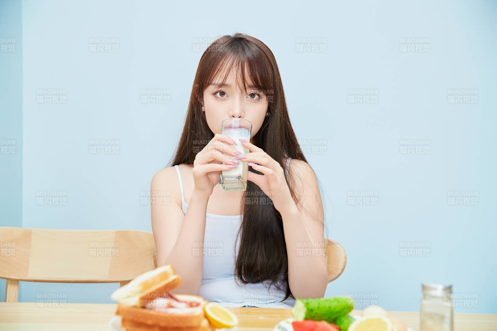 美丽的少女在餐桌前吃早餐图片