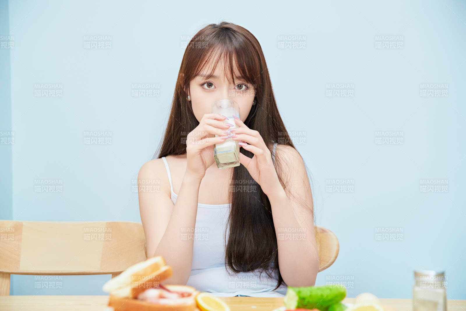 美丽的少女在餐桌前吃早餐图片