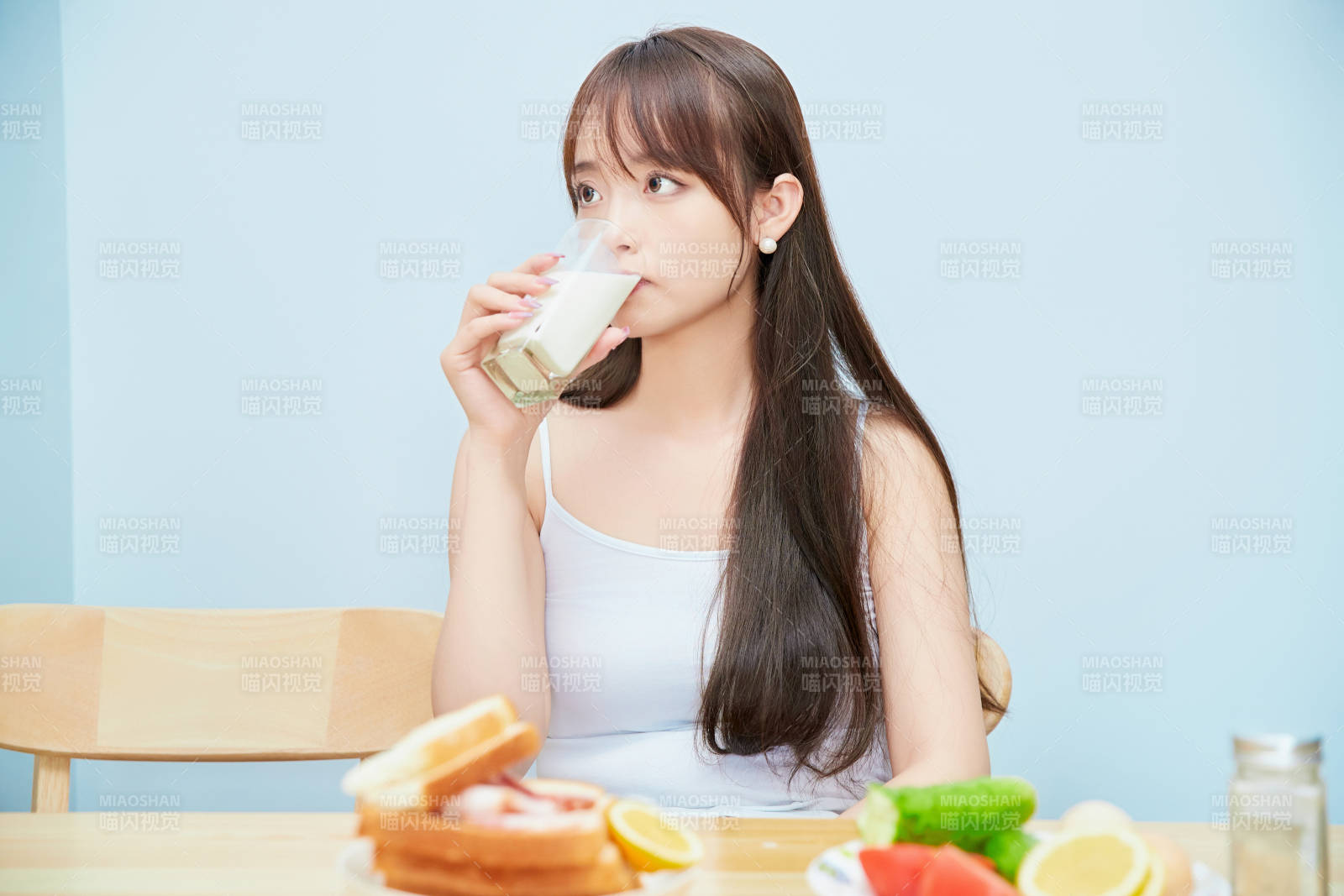 美丽的少女在餐桌前吃早餐图片