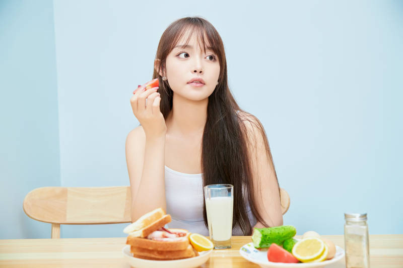 美丽的少女在餐桌前吃早餐图片