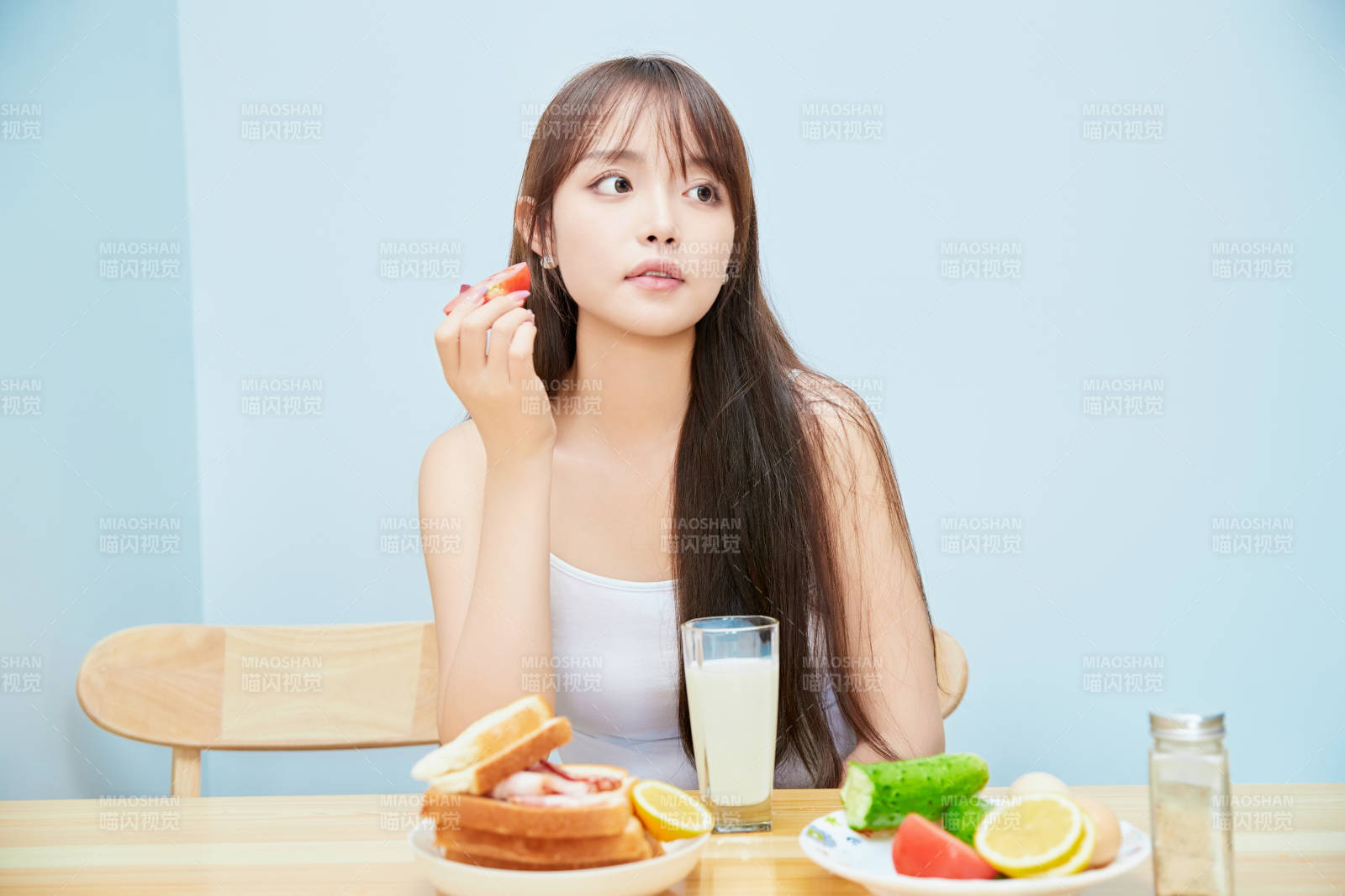 美丽的少女在餐桌前吃早餐图片