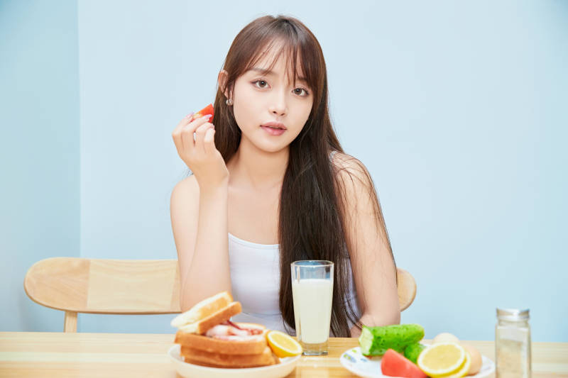 美丽的少女在餐桌前吃早餐图片