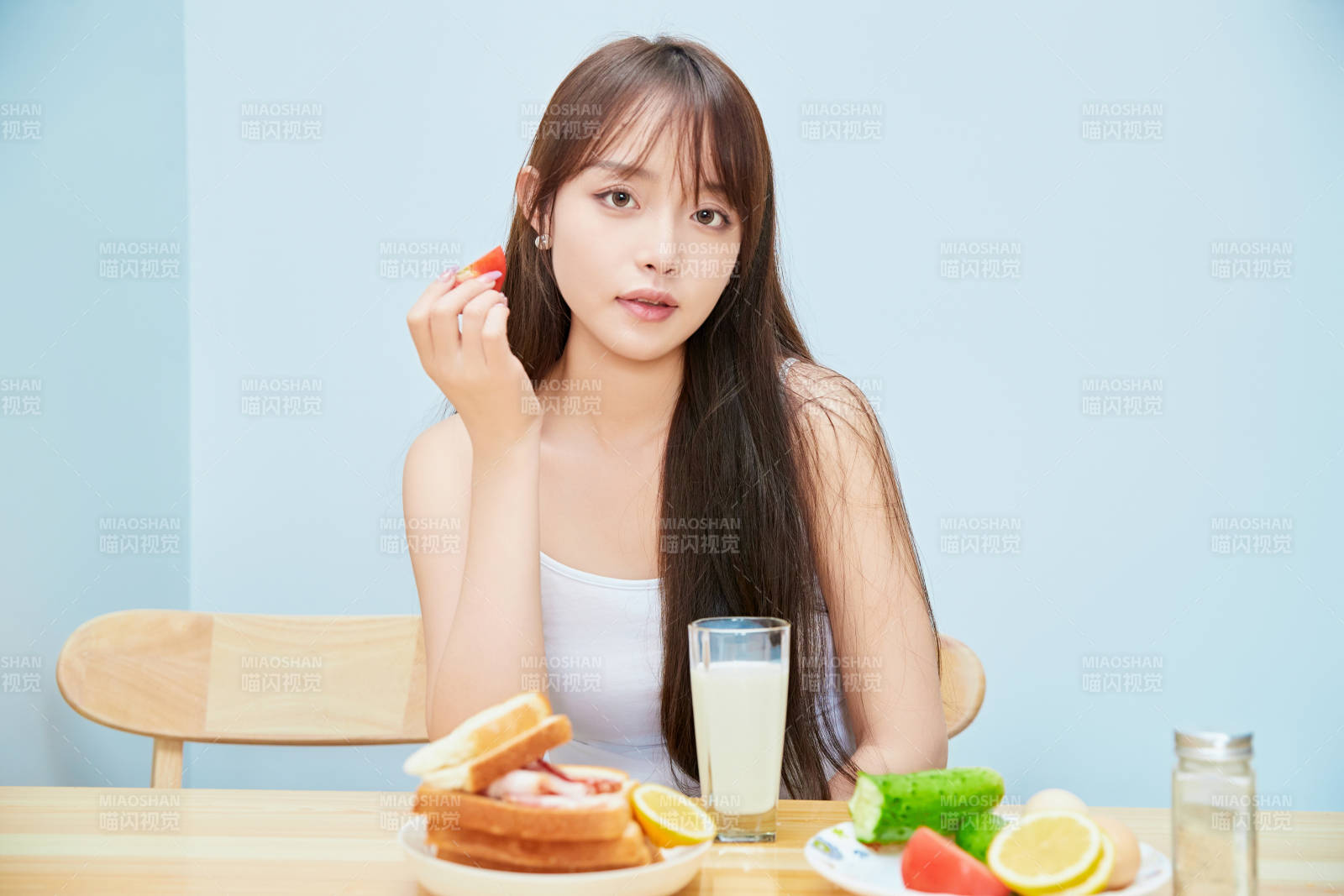 美丽的少女在餐桌前吃早餐图片