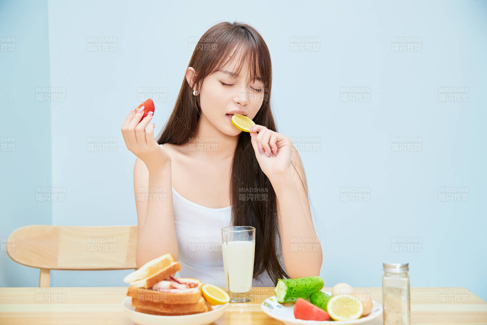 美丽的少女在餐桌前吃早餐图片