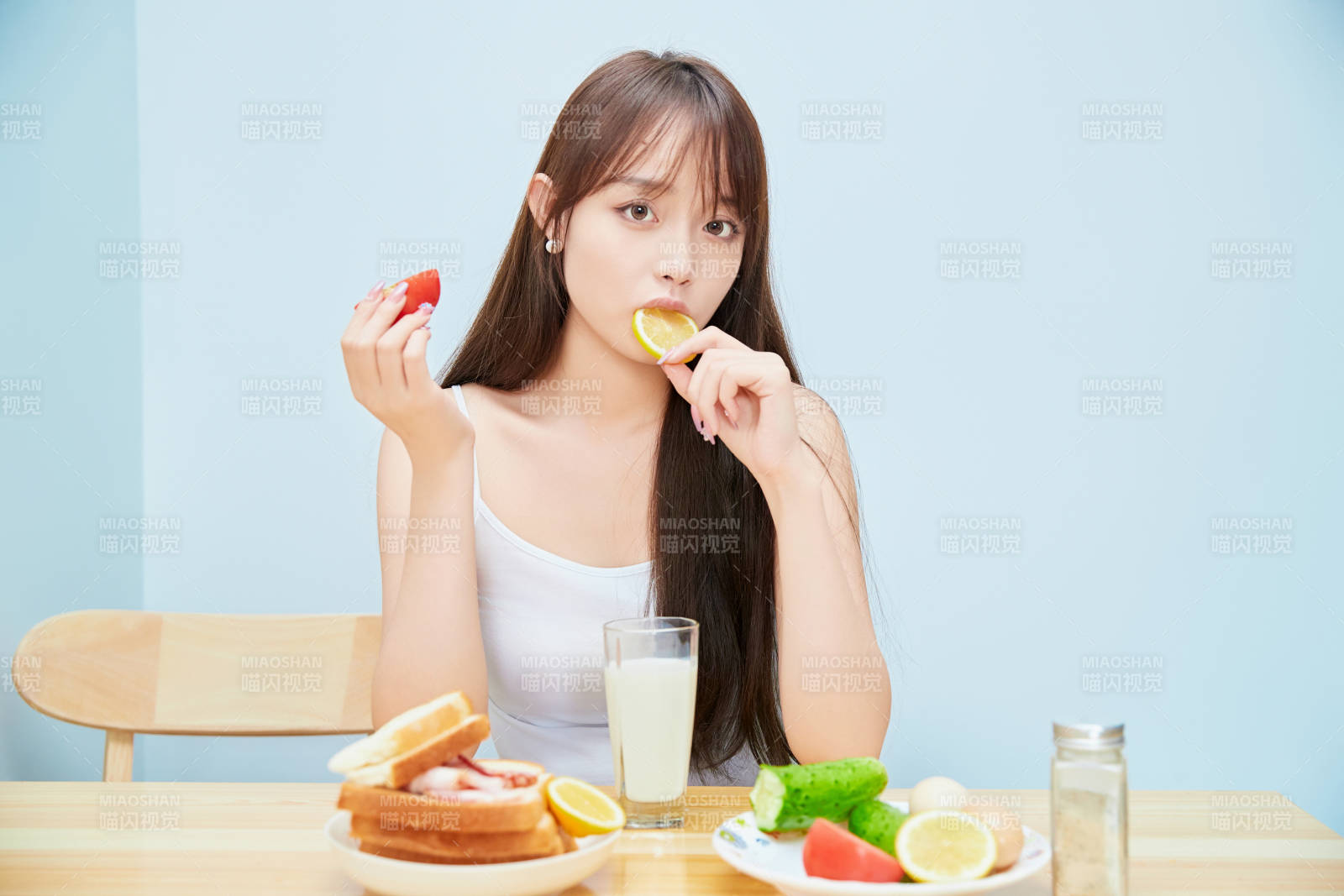 美丽的少女在餐桌前吃早餐图片