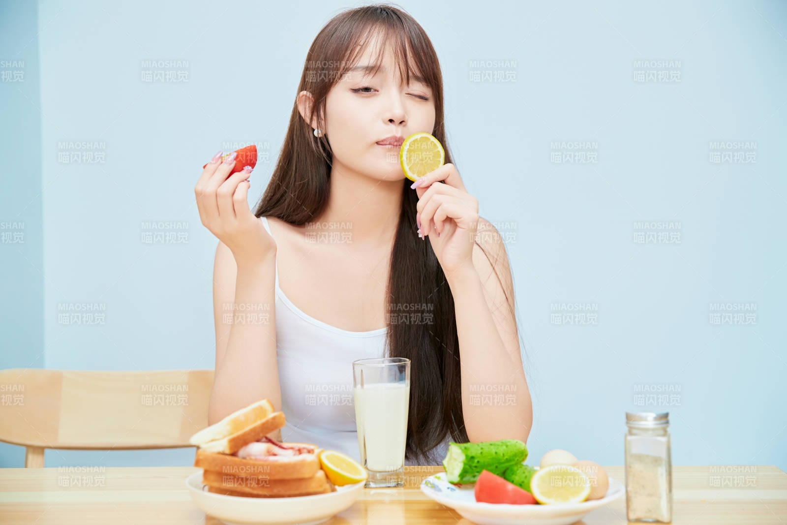 美丽的少女在餐桌前吃早餐图片