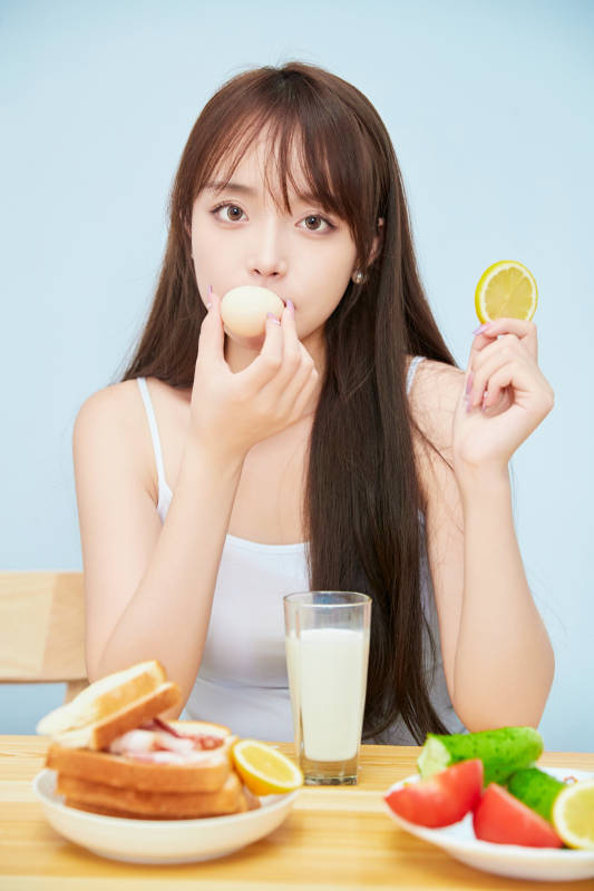 美丽的少女在餐桌前吃早餐图片