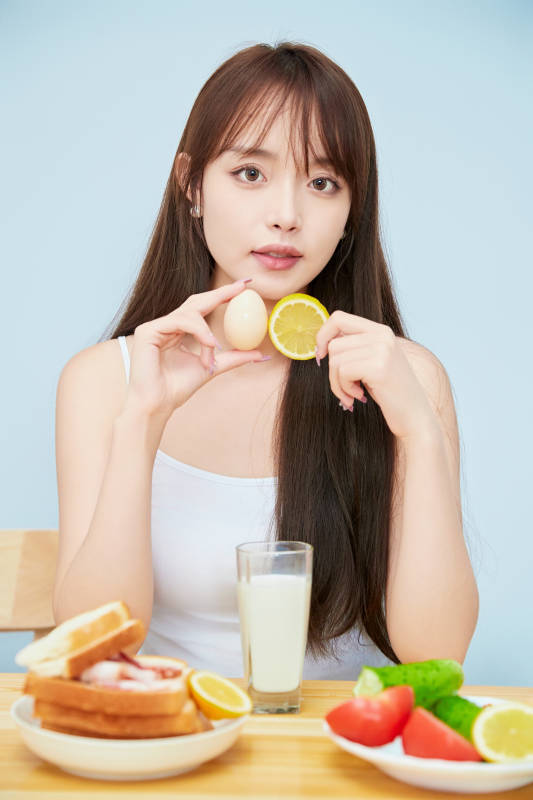 美丽的少女在餐桌前吃早餐图片