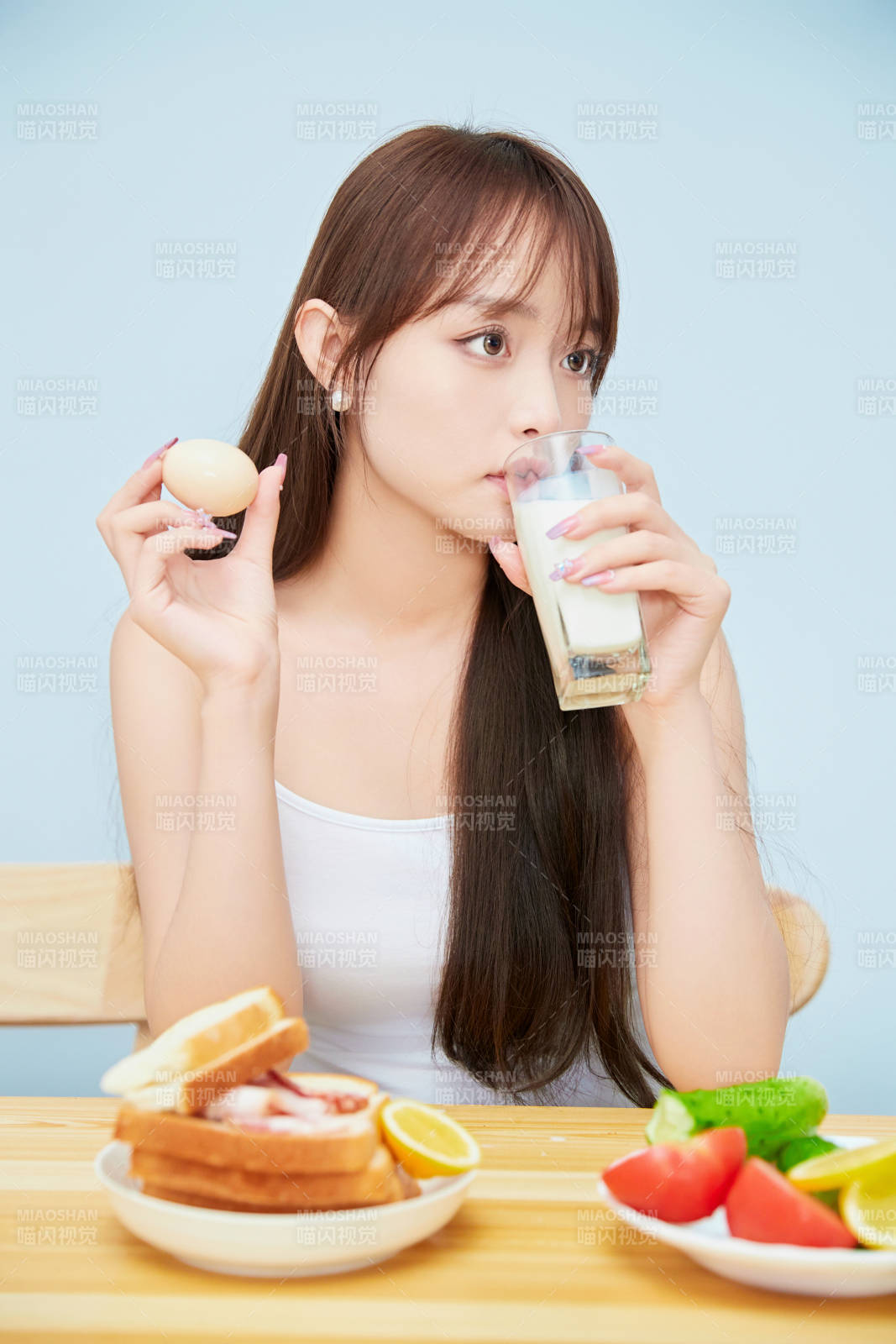 美丽的少女在餐桌前吃早餐图片