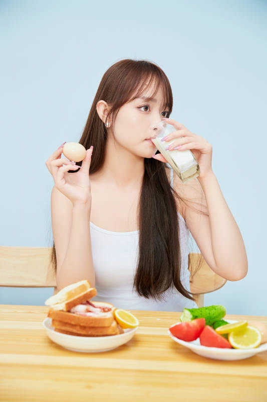 美丽的少女在餐桌前吃早餐图片