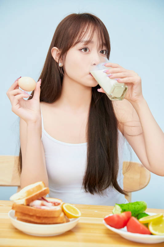 美丽的少女在餐桌前吃早餐图片