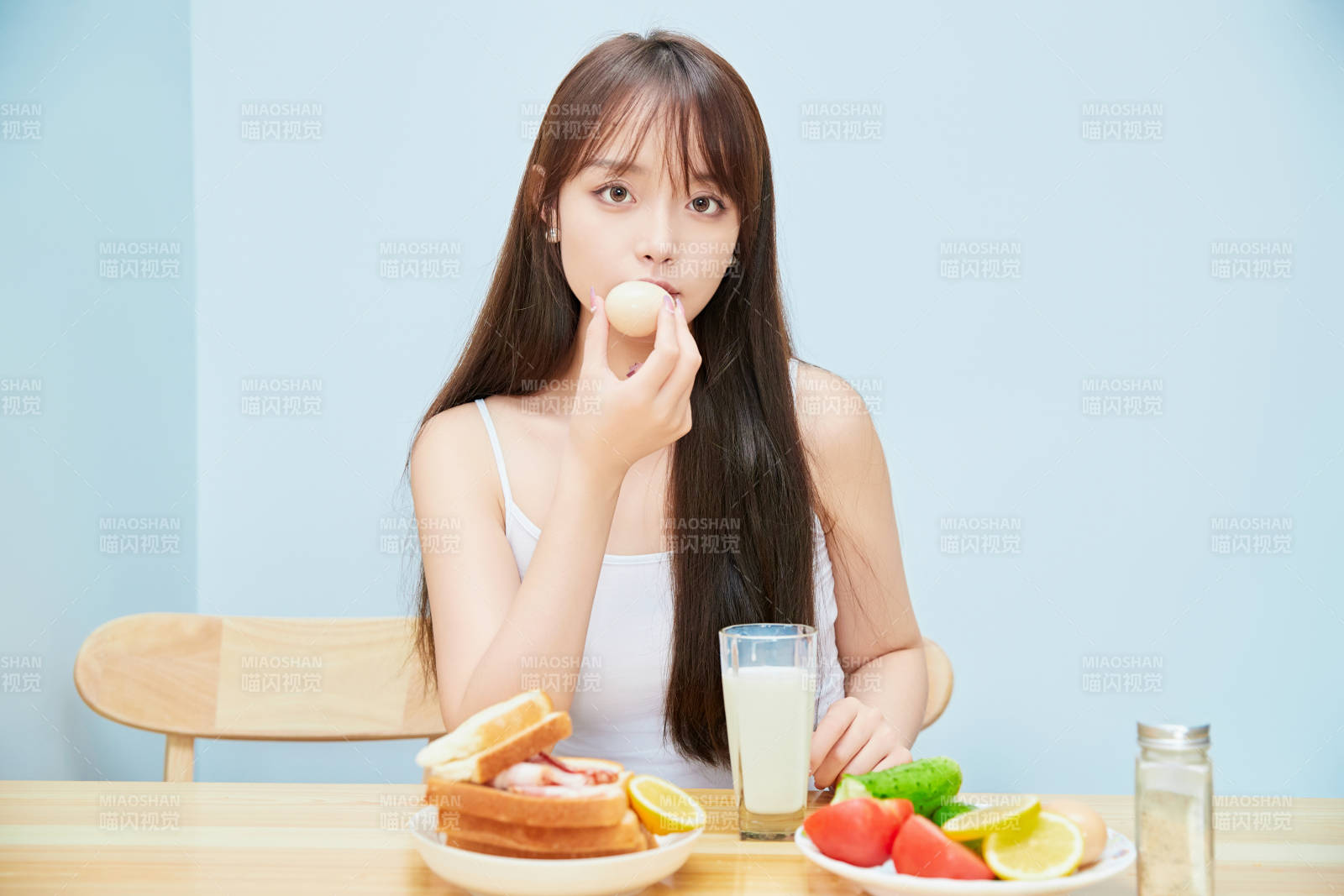 美丽的少女在餐桌前吃早餐图片