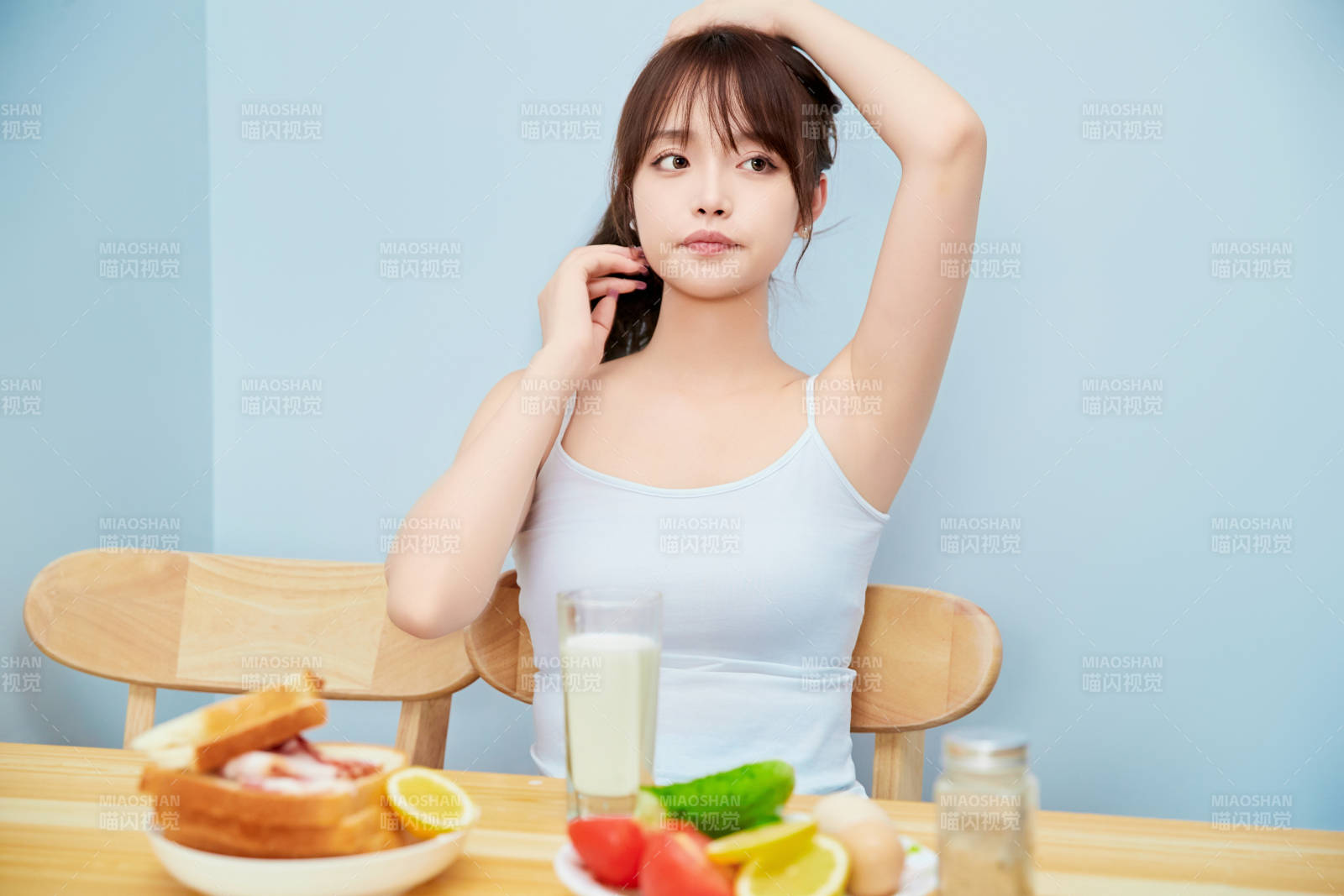 美丽的少女在餐桌前吃早餐图片