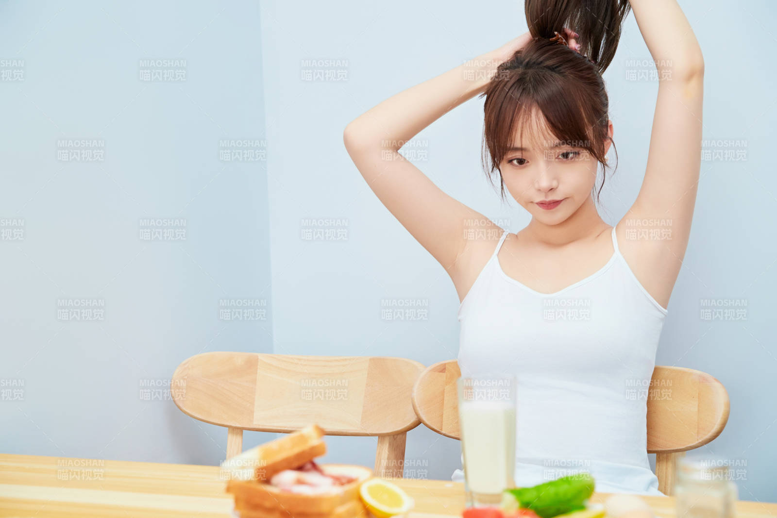 美丽的少女在餐桌前吃早餐图片