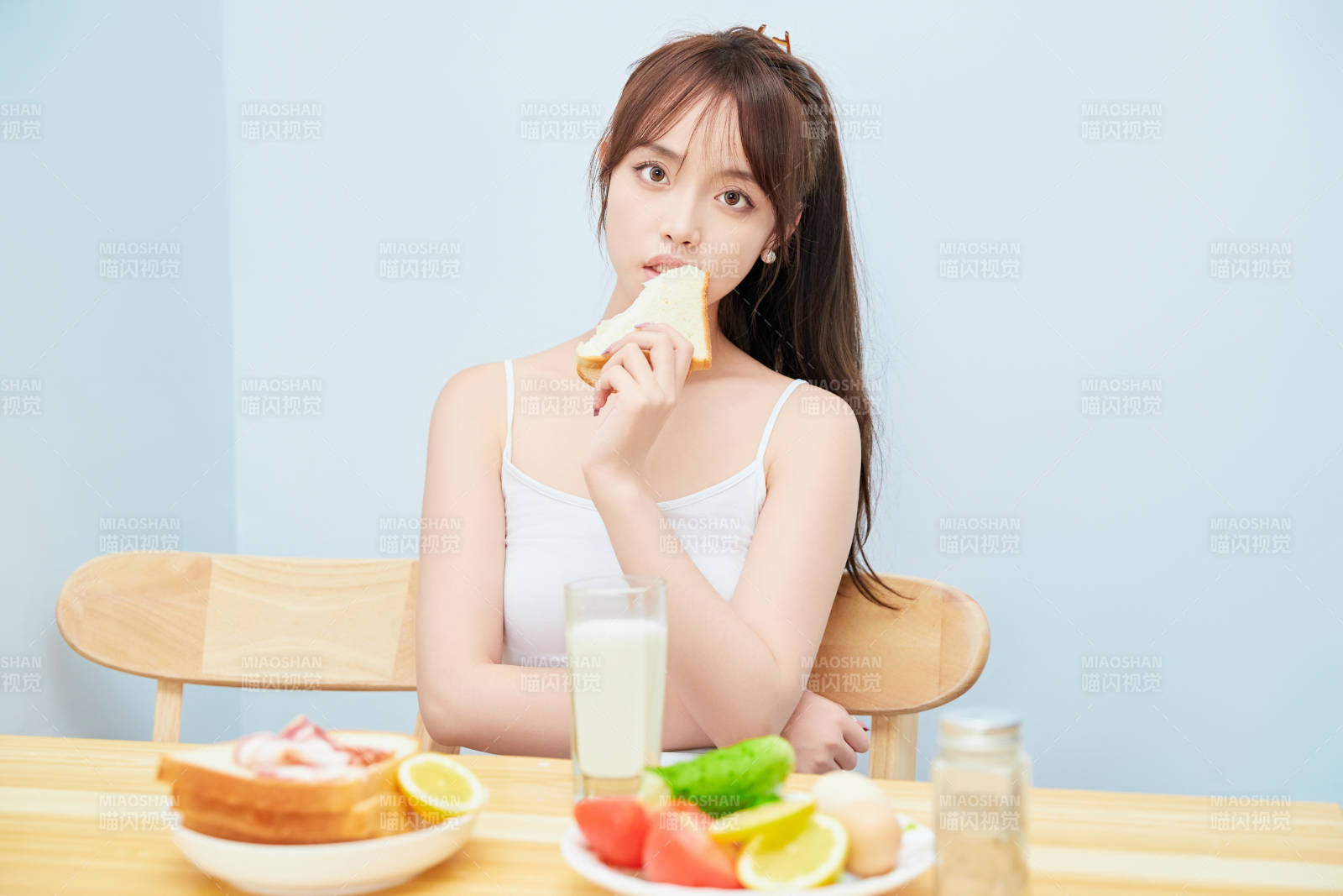 美丽的少女在餐桌前吃早餐图片