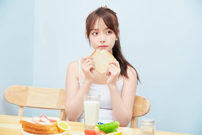 美丽的少女在餐桌前吃早餐图片