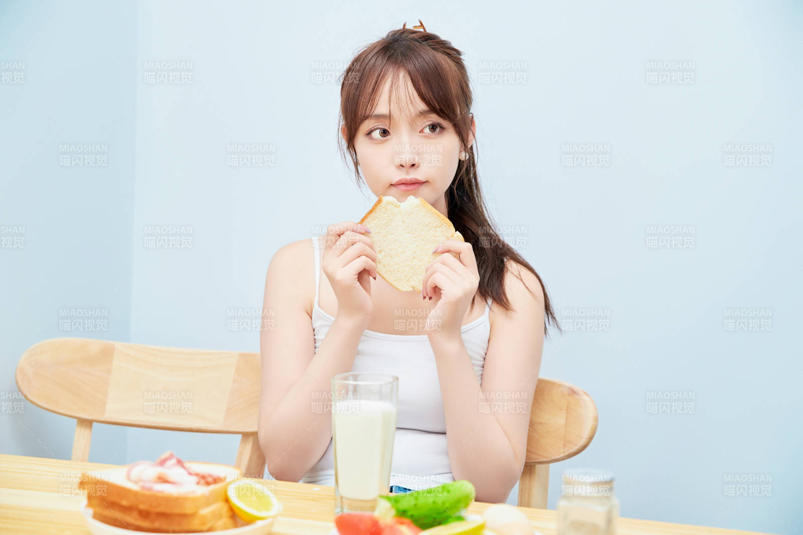 美丽的少女在餐桌前吃早餐图片