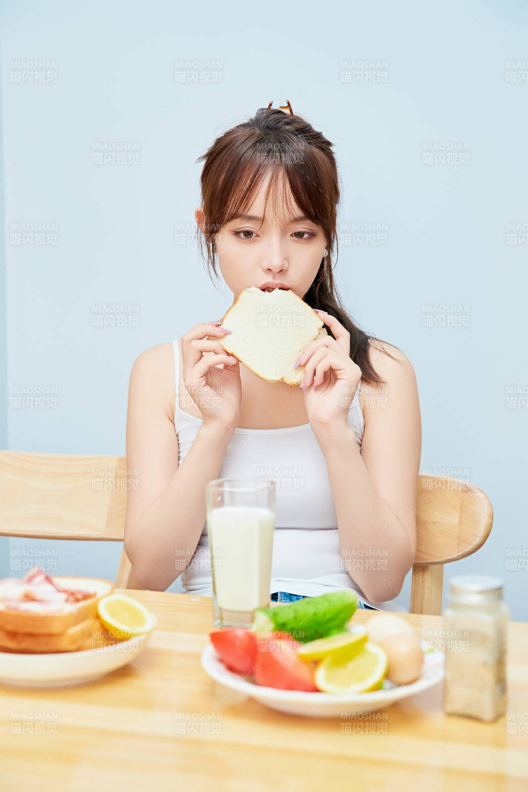 美丽的少女在餐桌前吃早餐图片