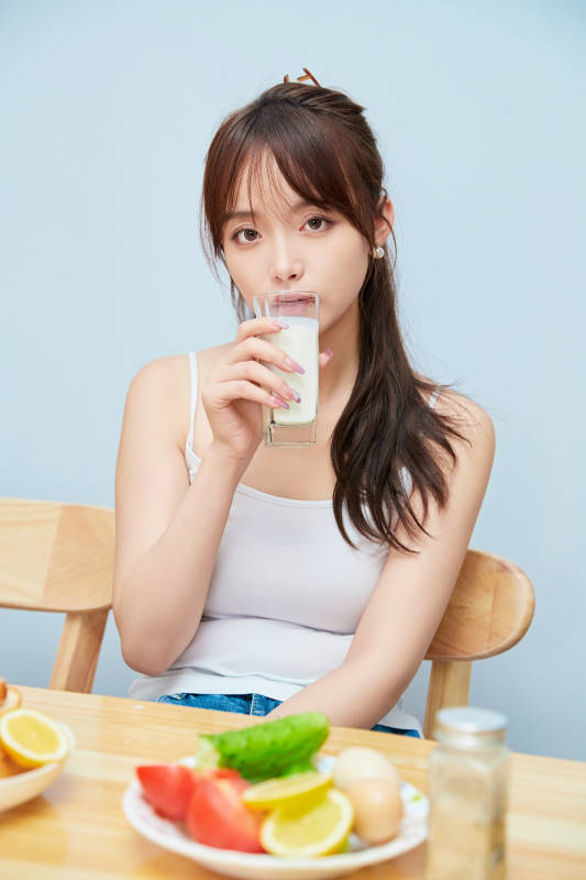 美丽的少女在餐桌前吃早餐图片