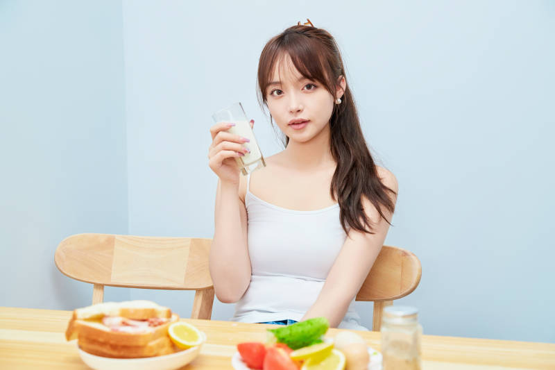 美丽的少女在餐桌前吃早餐图片