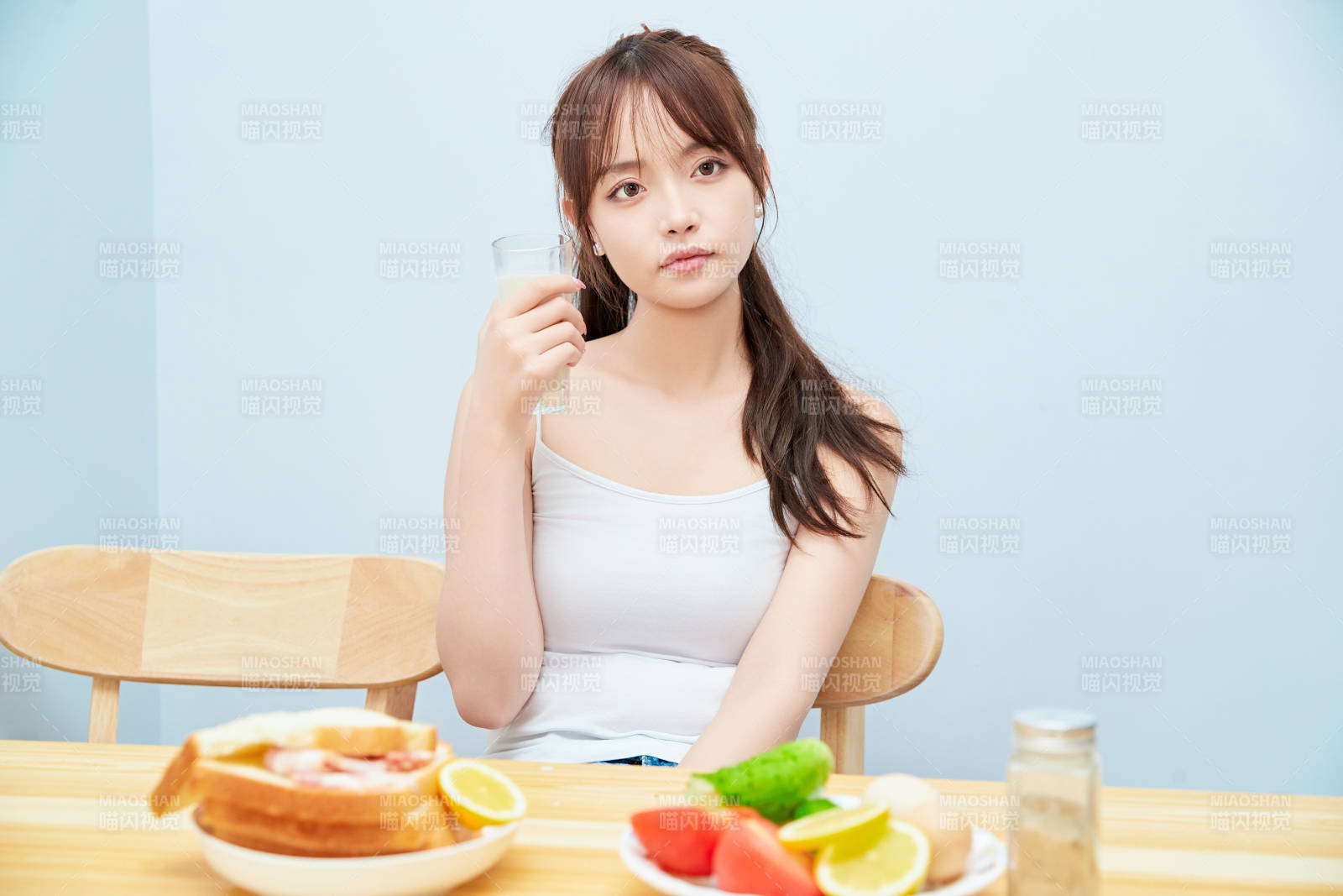 美丽的少女在餐桌前吃早餐图片