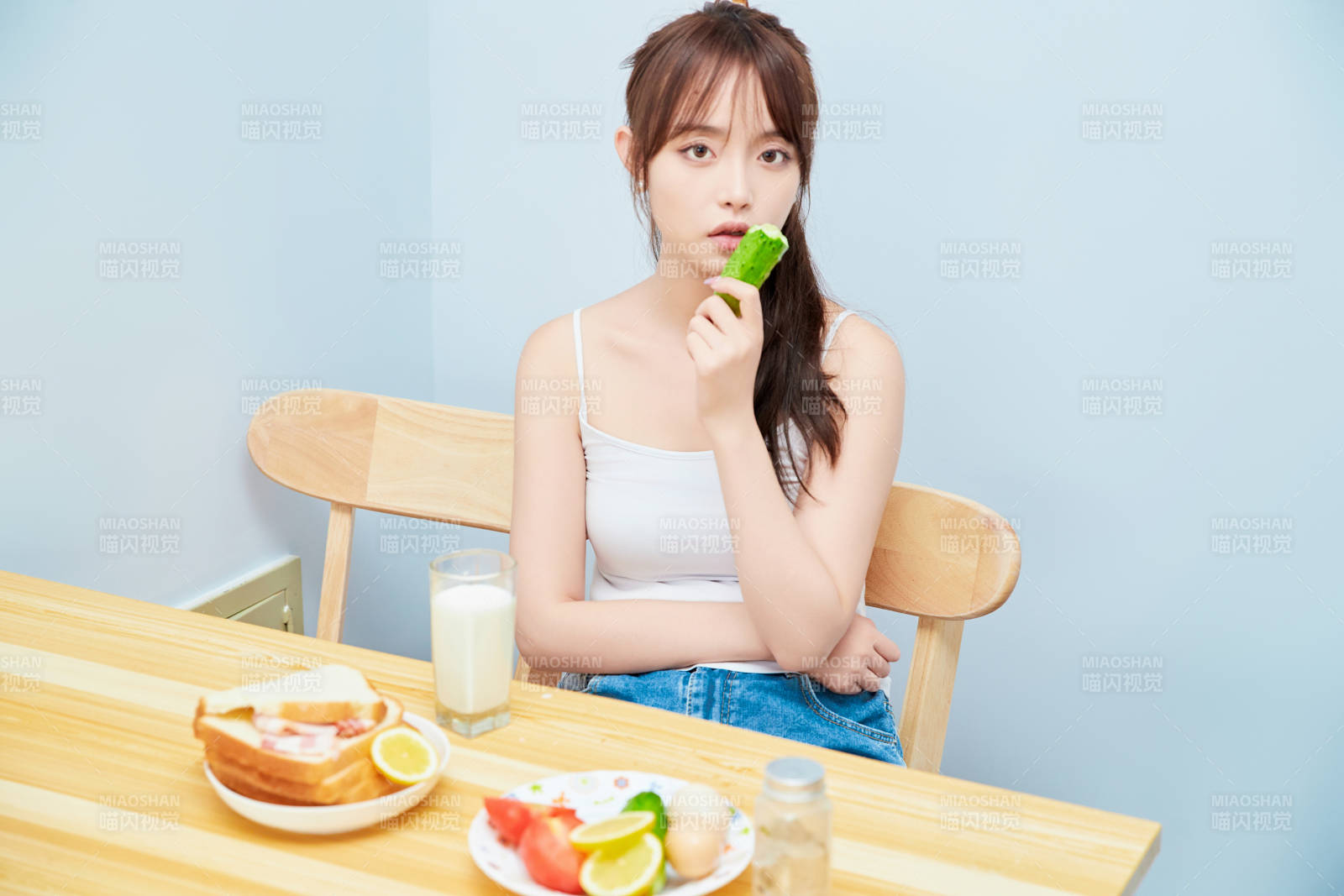美丽的少女在餐桌前吃早餐图片