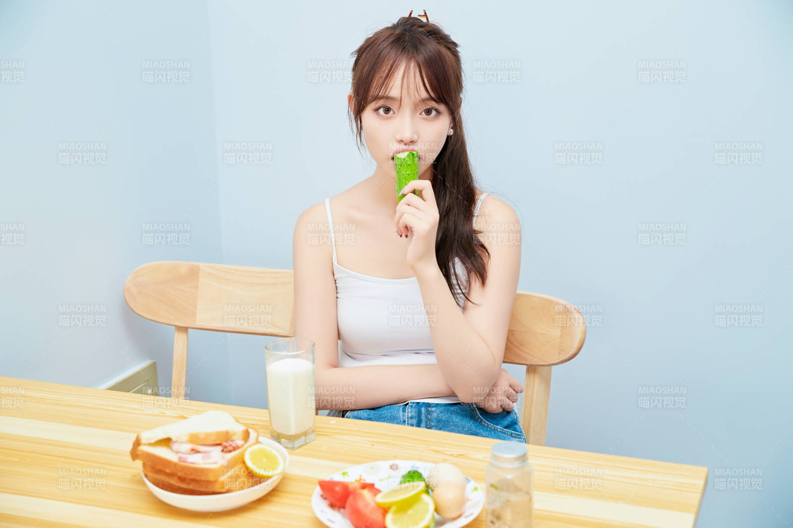 美丽的少女在餐桌前吃早餐图片