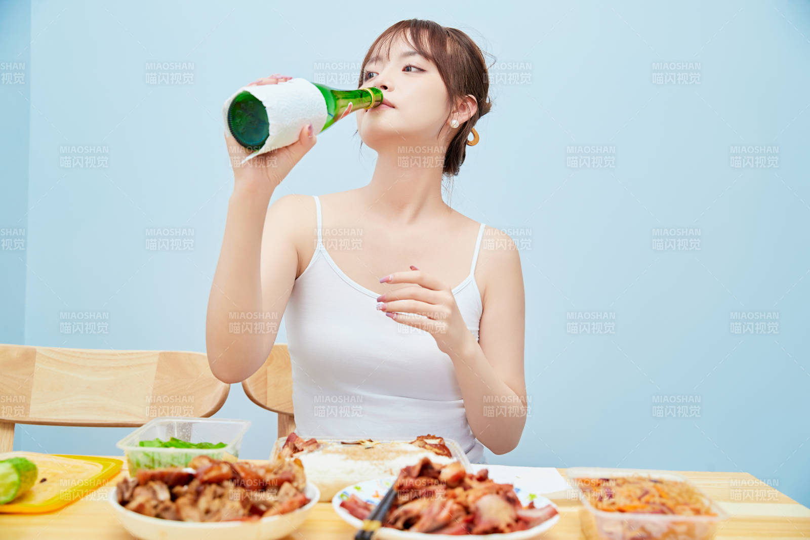 在餐桌前吃午餐喝白酒的亚洲少女图片