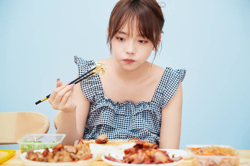 在餐桌前吃午餐的亚洲少女图片