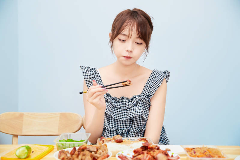 在餐桌前吃午餐的亚洲少女图片