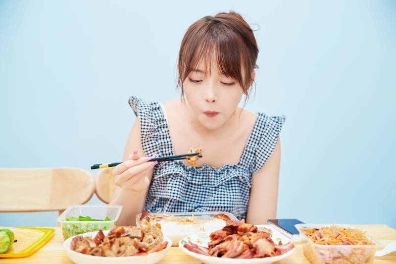 在餐桌前吃午餐的亚洲少女图片