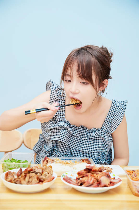 在餐桌前吃午餐的亚洲少女图片