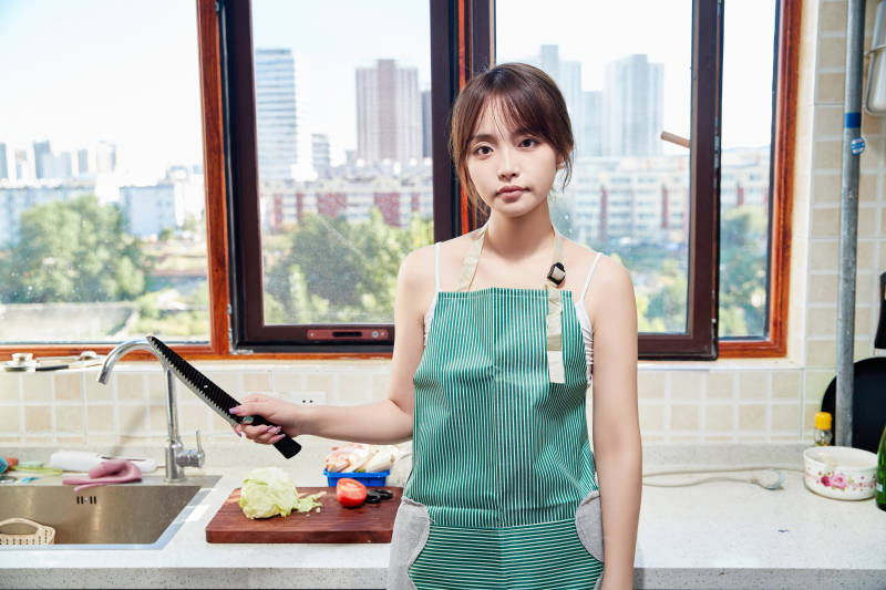 在厨房下厨做饭的年轻亚洲女性图片