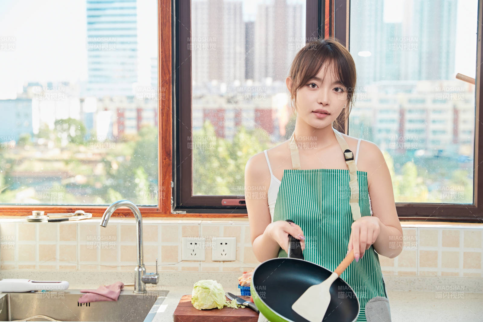 在厨房下厨做饭的年轻亚洲女性图片